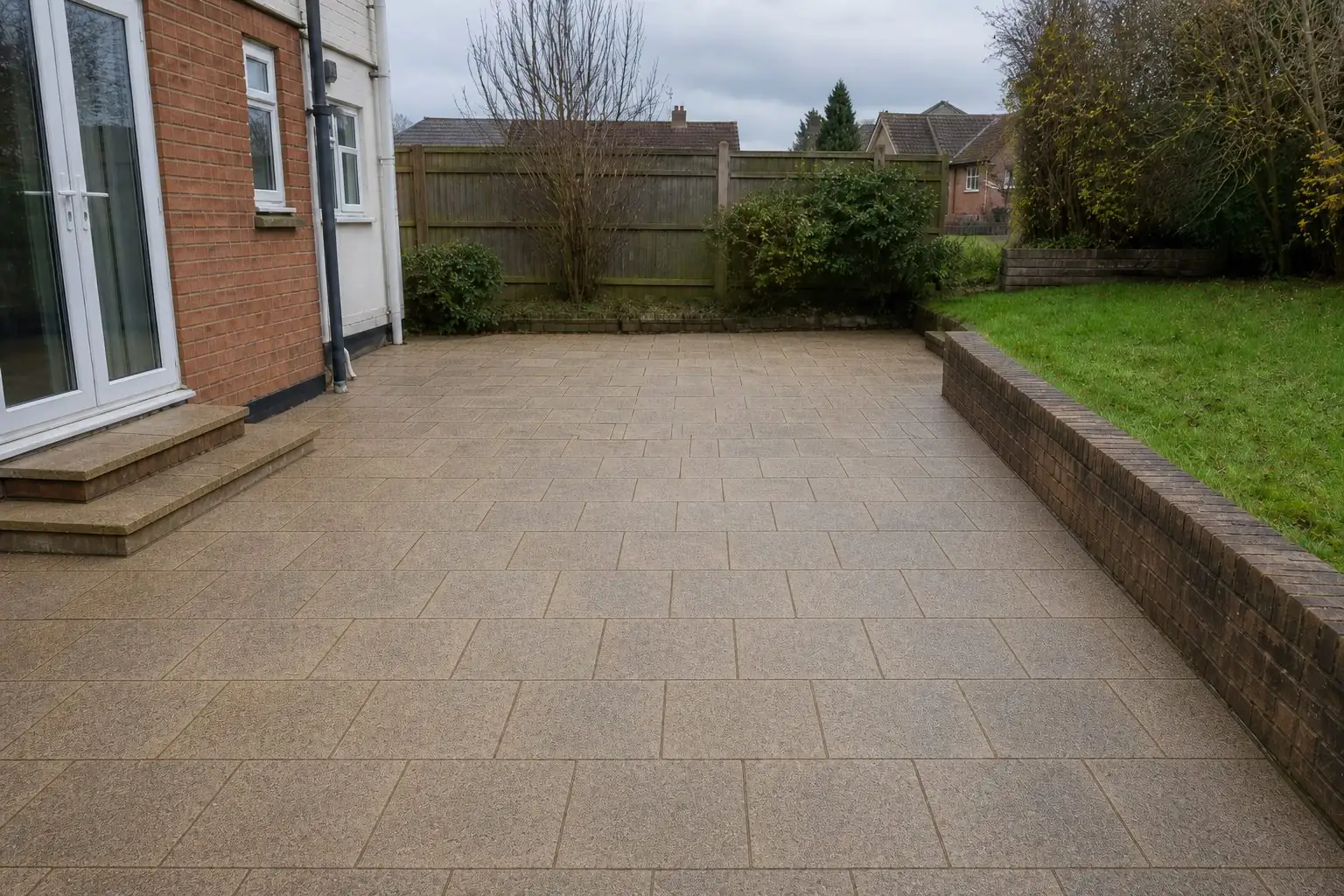 A patio after pressure washing, the slabs back to clean buff stone
