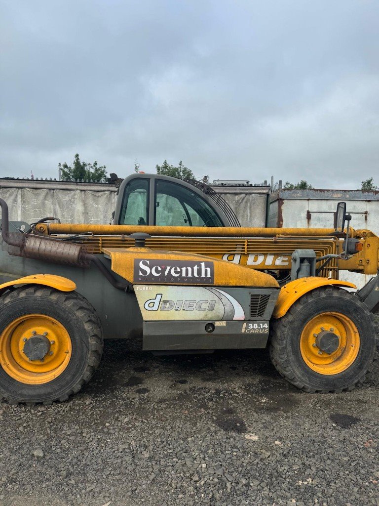 Telehandler halfway through a clean, with the yellow body washed and the boom still dirty